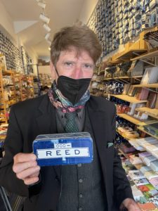 Reed Kirk Rahlmann, owner of Small Car Big Time Tours, holding a tin with his name on it.