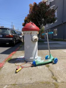 Scooter and raquets next to a fire hydrant in San Francisco.